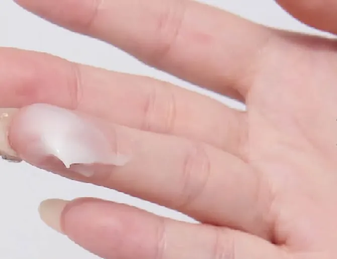 Ujung jari dengan krim Lume Advanced Barrier Moisturizer bertekstur creamy