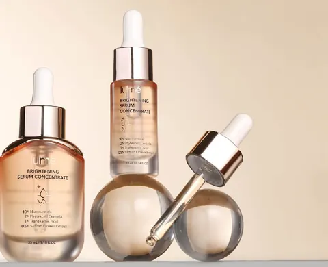 Botol Brightening Serum Concentrate 35 mL dan 10 mL serta pipet di atas bola kaca
