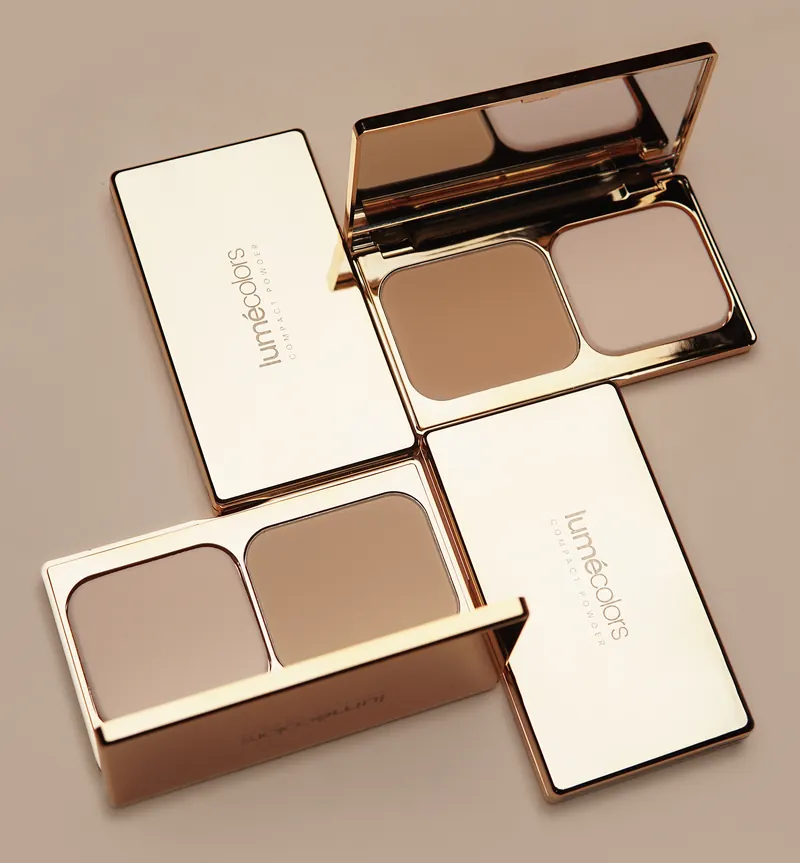 Empat Lumécolors Compact Powder berbingkai emas, dua terbuka memperlihatkan bedak dan spons
