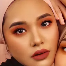Model berhijab pink dengan eyeshadow oranye-merah
