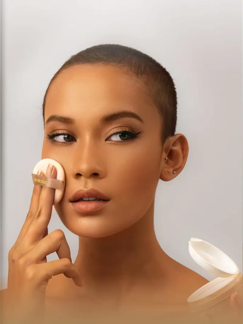 Model berkulit sawo matang menepuk puff Loose Powder shade Golden Tan ke pipinya