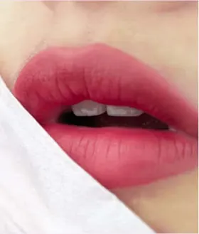 Bibir pink matte dengan selembar tisu di sudutnya